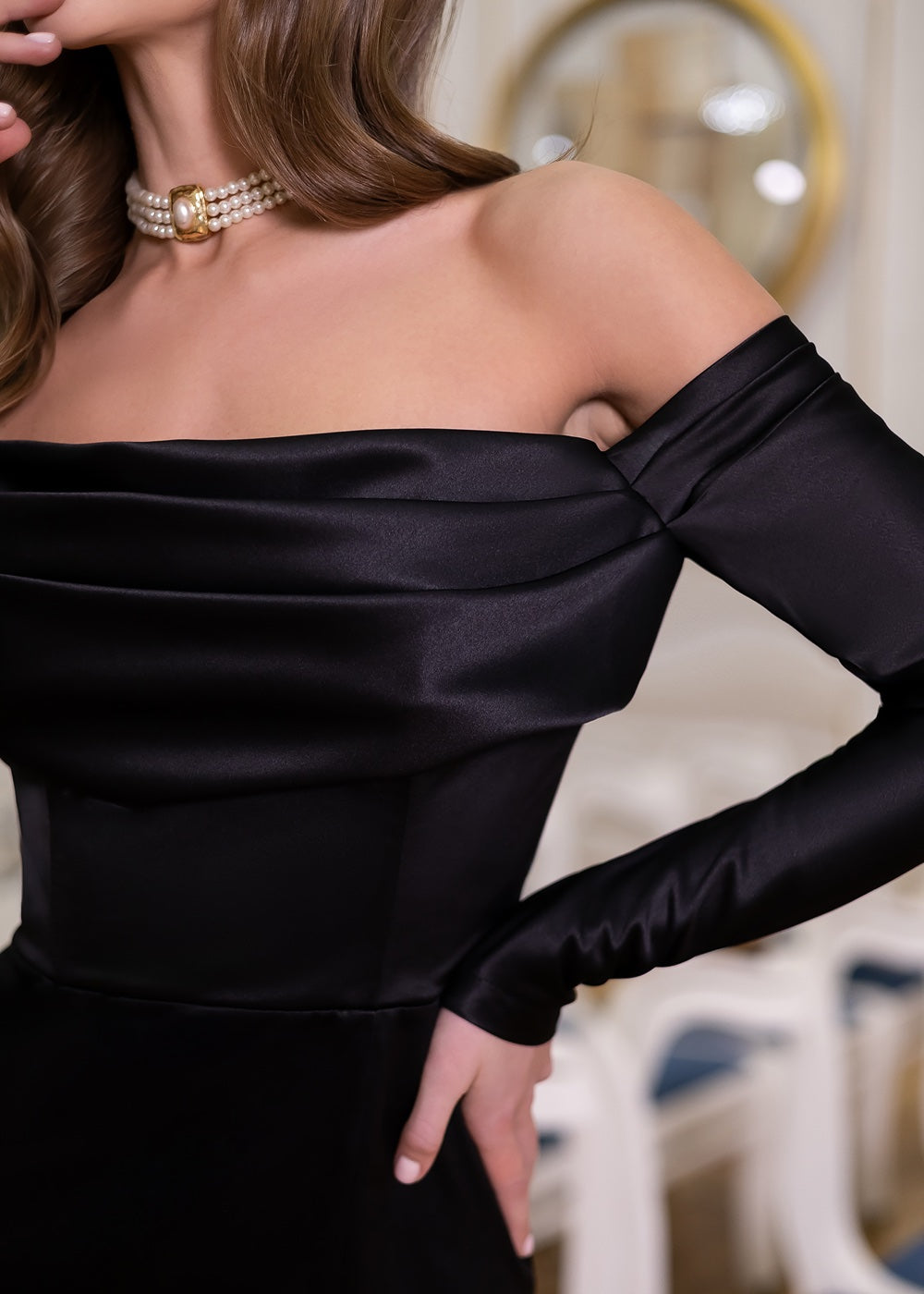 Чорна сатинова максі-сукня з відкритими плечима й довгими рукавами