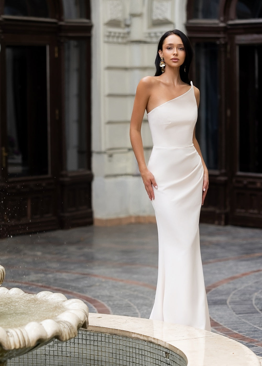 Біла максі сукня на одне плече з асиметричним кроєм і приталеним силуетом
